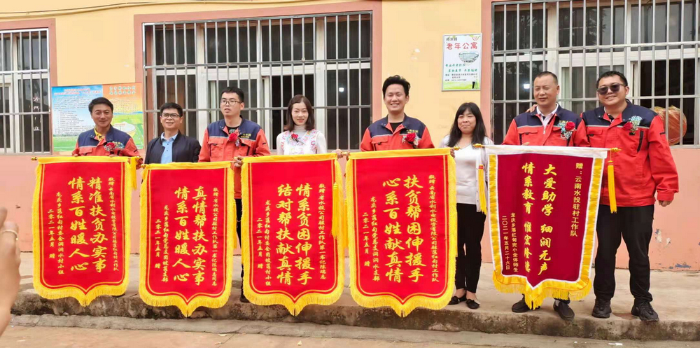 老队员手捧落红甸村各界人士赠送锦旗合照.jpg